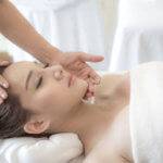 beautiful and healthy young woman relaxing with face massage  at beauty spa salon