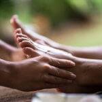 Close up of human hands massaging a woman's foot.