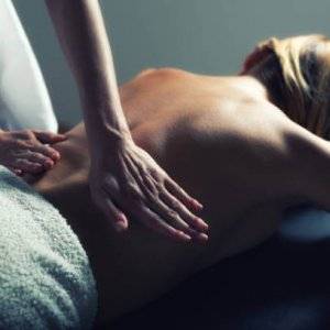 Woman getting back massage in professional massage salon.